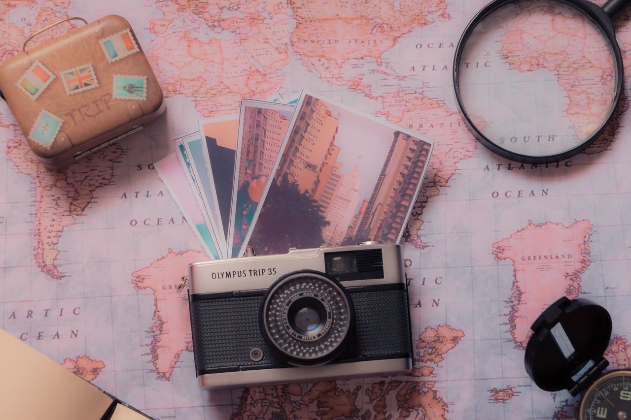services-03 Explore vintage photography with a classic camera and travel-themed setup over a world map.