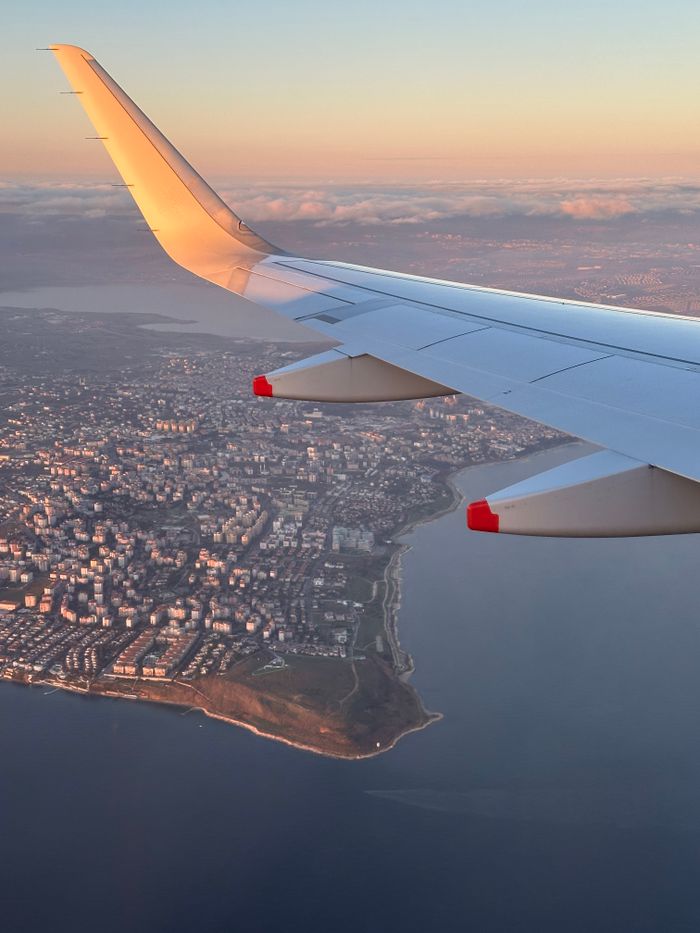 who-we-are Sunset aerial view of Istanbul city from airplane wing, serene sky and landscape.
