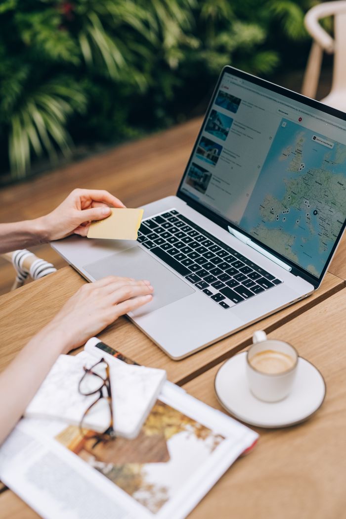 Mastering the First Impression: Your intriguing post title goes here A person using a laptop and credit card, surrounded by a magazine and coffee cup.